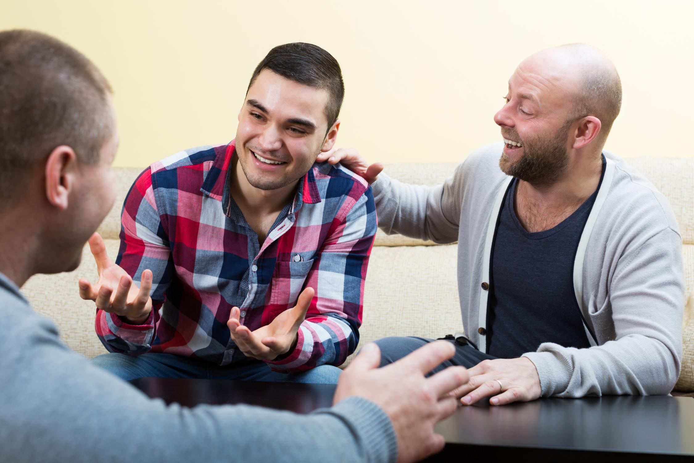 Drie mannelijke personen in gesprek 